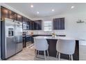 Modern kitchen boasts stainless steel appliances, dark cabinets, quartz countertops, and a central island with seating at 824 Ofanto Way, Haines City, FL 33844