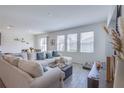 Bright living room featuring a large sectional sofa, wood floors, and large windows providing ample natural light at 824 Ofanto Way, Haines City, FL 33844