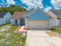 Charming one-story blue home with a two-car garage and manicured front yard at 8322 Cascade Oaks Dr, Orlando, FL 32822