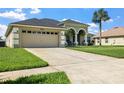 Front exterior view of home with spacious driveway and manicured front lawn and mature landscaping at 952 Chamberlin Trl, St Cloud, FL 34772