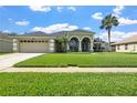 Charming single-Gathering home with manicured lawn, two-car garage, and beautiful arched entryway at 952 Chamberlin Trl, St Cloud, FL 34772