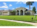 Charming single-Gathering home with manicured lawn, two-car garage, and beautiful arched entryway at 952 Chamberlin Trl, St Cloud, FL 34772