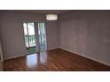 The dining room features hardwood floors, neutral paint, a modern light fixture and sliding glass doors to balcony at 9916 Sweepstakes Ln # 7, Orlando, FL 32837