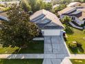 An aerial view of the house showing the roof, lawn, driveway, and surrounding neighborhood at 11730 Kennington Ct, Orlando, FL 32824