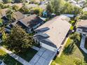 An aerial view shows this house's roof, driveway, and lawn along with the neighborhood at 11730 Kennington Ct, Orlando, FL 32824