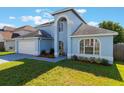 Stylish two-story home boasting an attached garage and lush green lawn at 12303 Bohannon Blvd, Orlando, FL 32824