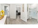 Open entryway with wood-look flooring, leading to a bathroom with a glass-enclosed shower and a living room at 14416 Orchid Island Dr, Orlando, FL 32827