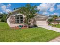 Charming single-Gathering home featuring a stone facade, manicured lawn, and two car garage at 1746 Golfview Dr, Kissimmee, FL 34746