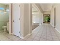 Bright hallway with tiled floors leading to the living area and bathroom with a glass shower at 1746 Golfview Dr, Kissimmee, FL 34746
