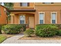 Charming front entrance with covered porch, lush landscaping, and brick walkway at 203 La Mirage St, Davenport, FL 33897