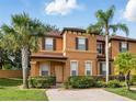 Inviting two-story townhome with neutral stucco exterior, manicured landscaping, and brick-paved driveway at 203 La Mirage St, Davenport, FL 33897