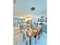 Open-concept dining area with a wooden table, adjacent to the kitchen and bright natural light at 2547 Trielle Ave, Kissimmee, FL 34741