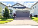Beautiful single-Gathering home with neutral exterior, green grass and a brick paved driveway at 2547 Trielle Ave, Kissimmee, FL 34741
