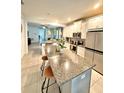 Modern kitchen featuring a large island with bar seating, stainless steel appliances, and tile flooring at 2547 Trielle Ave, Kissimmee, FL 34741