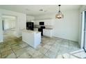 Bright kitchen featuring white cabinetry, modern black appliances, and an island with a breakfast bar at 2728 Portchester Ct, Kissimmee, FL 34744