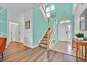 Inviting foyer showcasing wood-look floors, an open staircase, and a decorative arched window above the door at 303 Plumoso Loop, Davenport, FL 33897