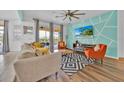 Bright living room with stylish furnishings, a ceiling fan, and glass sliding doors leading to an outdoor patio at 303 Plumoso Loop, Davenport, FL 33897