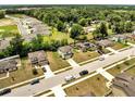 Aerial view of a neighborhood featuring many two-story homes, green lawns, and tree-lined streets at 320 Southern Winds Blvd, Deland, FL 32720