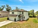 Corner lot, two-story home features an attached two-car garage, neutral color scheme and green lawn at 320 Southern Winds Blvd, Deland, FL 32720