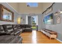 Cozy living room with vaulted ceiling, hardwood floors and oversized couch at 4981 Alita Ter, St Cloud, FL 34769
