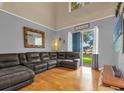 Well-lit living room features a comfortable sectional, hardwood floors and vaulted ceiling at 4981 Alita Ter, St Cloud, FL 34769