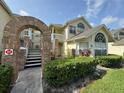 Charming condo building featuring brick accents and a welcoming arched entrance under a partially cloudy sky at 5017 Laguna Bay Cir # 96, Kissimmee, FL 34746