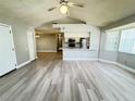Bright and spacious living area with new wood-look flooring, a ceiling fan, and open access to the kitchen at 5017 Laguna Bay Cir # 96, Kissimmee, FL 34746