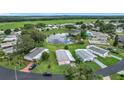 An aerial view showcasing the community with a lake, pool, and well-kept homes at 6044 Grand Oaks Se Dr, Winter Haven, FL 33884