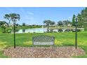 A serene community pond featuring a fountain and bench seating for relaxation at 6044 Grand Oaks Se Dr, Winter Haven, FL 33884