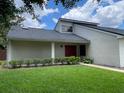 Inviting home featuring a red front door, green landscaping, and an eye-catching architectural design at 7200 Green Pine Ct, Orlando, FL 32819