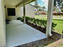 Covered front porch with white floor, columns, dark bench and decorative shrubbery at 7200 Green Pine Ct, Orlando, FL 32819