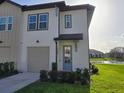 Charming two-story townhome with a well-manicured lawn, a lake view, and a cozy front porch at 726 Longboat, Davenport, FL 33896