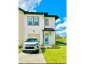 Two-story home with a modern white exterior, a front-facing garage, and manicured lawn at 726 Longboat, Davenport, FL 33896