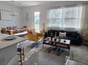 Bright living room with modern furnishings, large windows, and an open floor plan leading to the dining area at 726 Longboat, Davenport, FL 33896