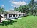 Single-story home featuring black trim, palm trees and an expansive lawn at 726 Marion Oaks Ln, Ocala, FL 34473