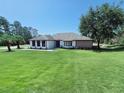 Attractive single-story home featuring green lawn, palm trees and a well manicured landscape at 726 Marion Oaks Ln, Ocala, FL 34473
