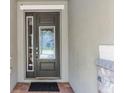 A close-up of a front door with sidelight and decorative glass, plus stone accents at 7527 Marker Ave, Kissimmee, FL 34747