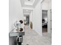 Bright hallway featuring modern tile flooring and stylish decor leading to bedroom at 8967 Chipping Square Ln, Davenport, FL 33896