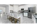 Modern kitchen featuring white cabinetry, stainless steel appliances, and a center island at 8967 Chipping Square Ln, Davenport, FL 33896