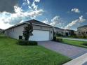 Exterior view of a home with a spacious driveway leading to a convenient two-car garage at 9318 Mclaren Aly, Winter Garden, FL 34787