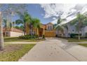 Charming two-story home with a well-manicured lawn and mature trees on a sunny day at 1101 Marcello Blvd, Kissimmee, FL 34746