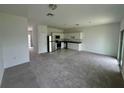 Open-concept living room featuring a kitchen with stainless steel appliances and carpeted flooring at 1140 Merrill St, Davenport, FL 33837