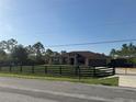 Charming one-story home with a well-maintained lawn, black wooden fence, and gated driveway at 18805 Nettleton St, Orlando, FL 32833