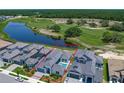 Aerial view of property showcasing a private pool, lush landscaping, and tranquil views of the adjacent pond and golf course at 235 Hampton Loop, Davenport, FL 33837