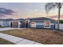 Attractive single-story home featuring a dark garage door, neutral paint, and a well-manicured lawn at 2520 Jasmine Trace Dr, Kissimmee, FL 34758