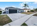 Attractive home featuring a dark garage door, neutral paint, and a spacious driveway at 2520 Jasmine Trace Dr, Kissimmee, FL 34758