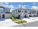 An eye-level view of new townhomes featuring a gray color palette and well manicured lawns at 2845 Pierr St, Davenport, FL 33837