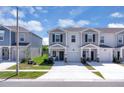 Exterior view of the townhomes with a well-maintained lawn and a concrete driveway at 2845 Pierr St, Davenport, FL 33837