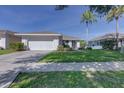 A well-kept single-story home with a two-car garage and green front lawn at 2908 Sunset Lakes Blvd, Kissimmee, FL 34747