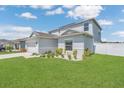 Two-story home featuring a well-manicured lawn, front landscaping, and a two-car garage on a sunny day at 374 Pine Tree Bridge Trl, St Cloud, FL 34772